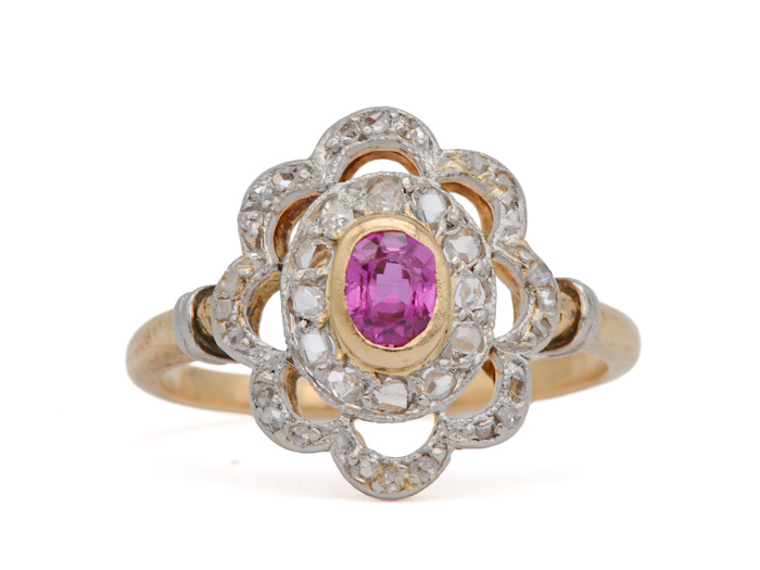 Bague Art Nouveau ancienne en or jaune et blanc, rubis central et diamants taille rose à décor de volutes