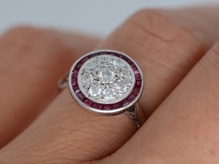 Bague Art Déco ronde rubis diamants en or blanc portée à la main